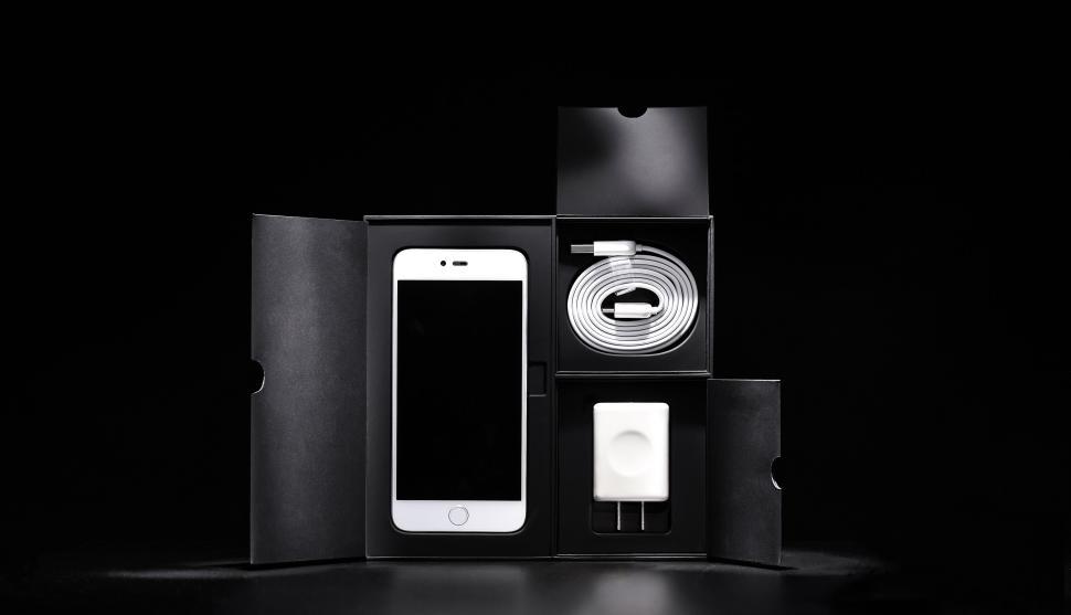 Free Image of Unboxed smartphone with charger and cable on black 