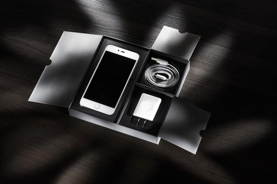 Free Image of Smartphone in packaging with accessories on table. 