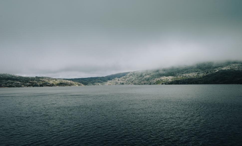 Free Image of Foggy lake scene with mountains in the background. 