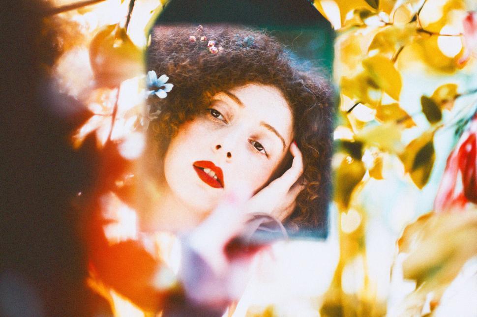 Free Image of Close-up of woman amid vibrant, colorful foliage outdoors. 