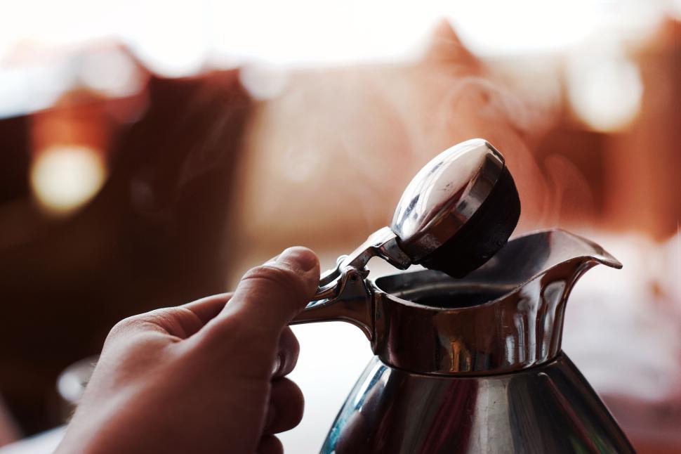 Free Image of Hand holding coffee pot preparing a fresh brew shot close-up 