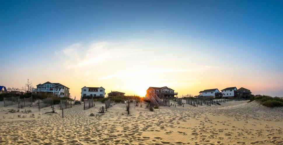 Free Image of Sunset view of beachfront houses on a sandy coastline side 