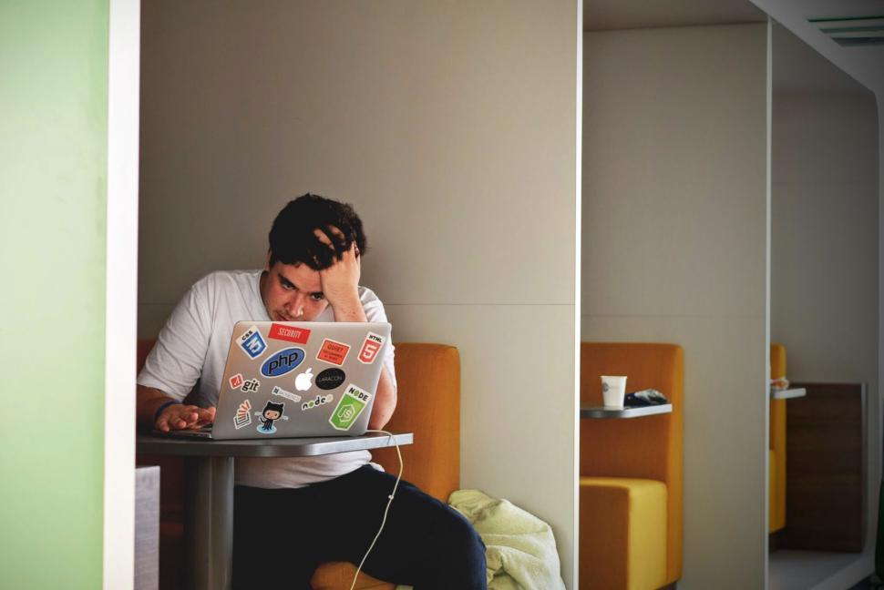 Free Image of Man working on laptop in a modern office setting. 