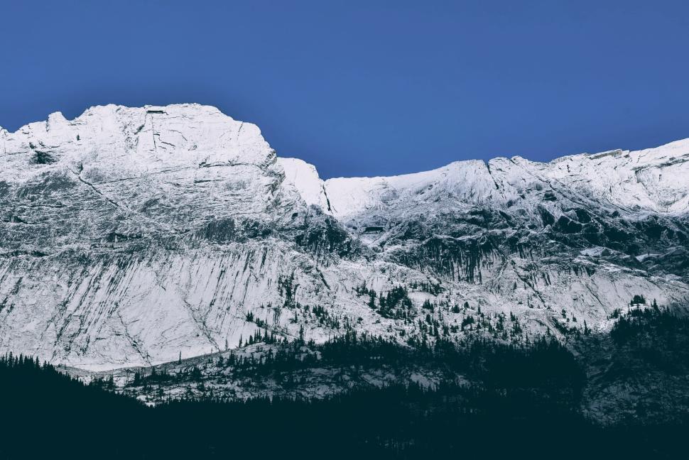Free Image of Snow-covered mountain peaks under a clear blue sky. 
