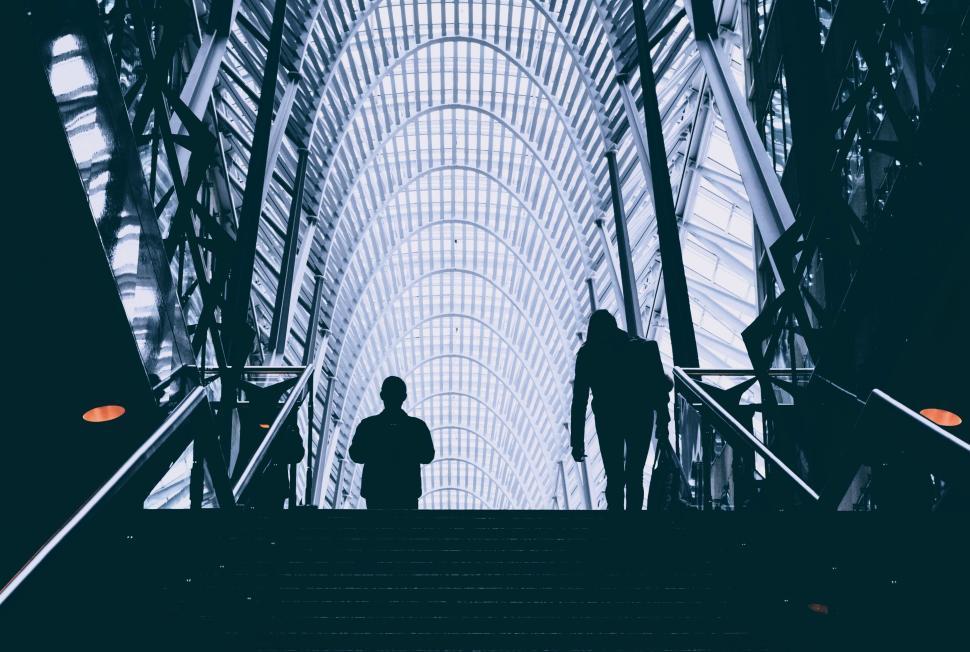 Free Image of People walking under an arched, patterned roof. 