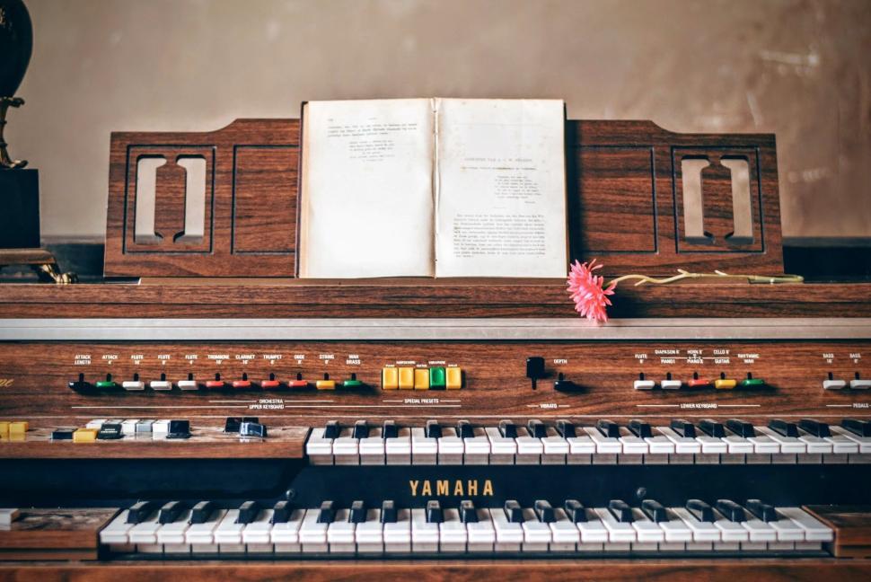 Free Image of Vintage Yamaha organ with sheet music and pink flower 