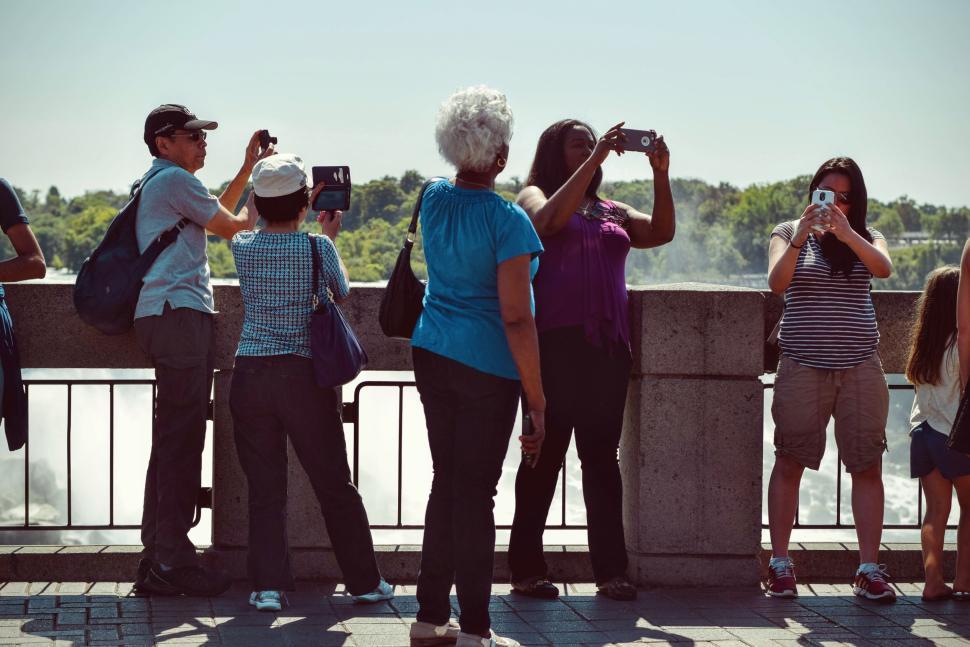 Free Image of Tourists taking photos at scenic outdoor attraction site. 