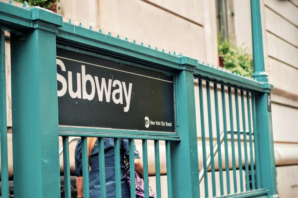 Free Image of New York City subway entrance with metal fence and sign. 