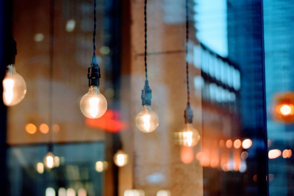 Free Image of Hanging light bulbs glowing in modern urban setting 