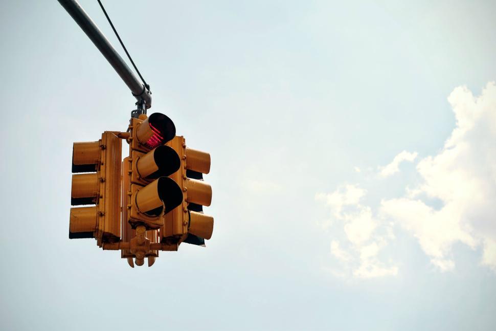 Free Image of Traffic light showing red signal against a clear blue sky 
