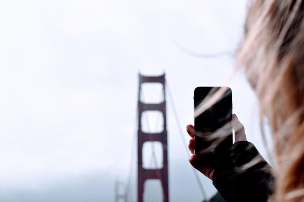 Free Image of Person taking a photo of the bridge on a cloudy day 