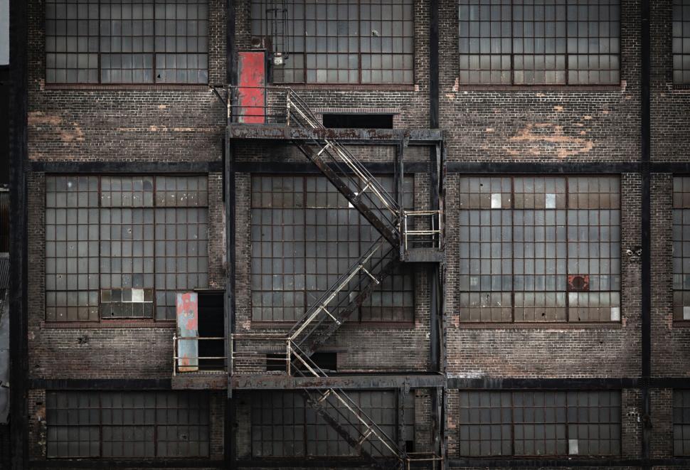 Free Image of Vintage industrial building exterior with red door. 