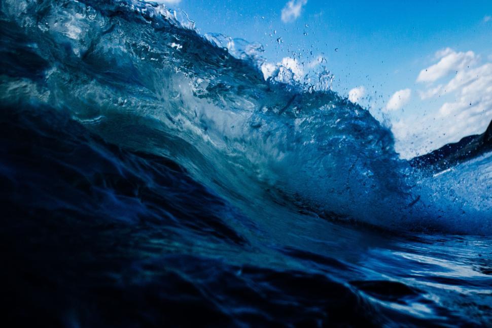 Free Image of Captivating ocean wave crashing under bright sky. 