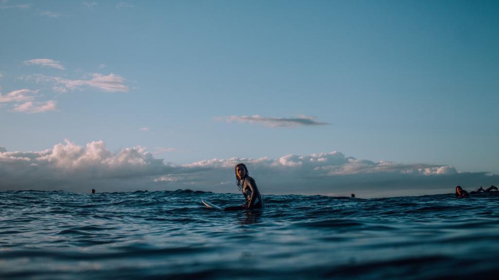 Free Image of Surfer sitting on a surfboard in the open ocean water 