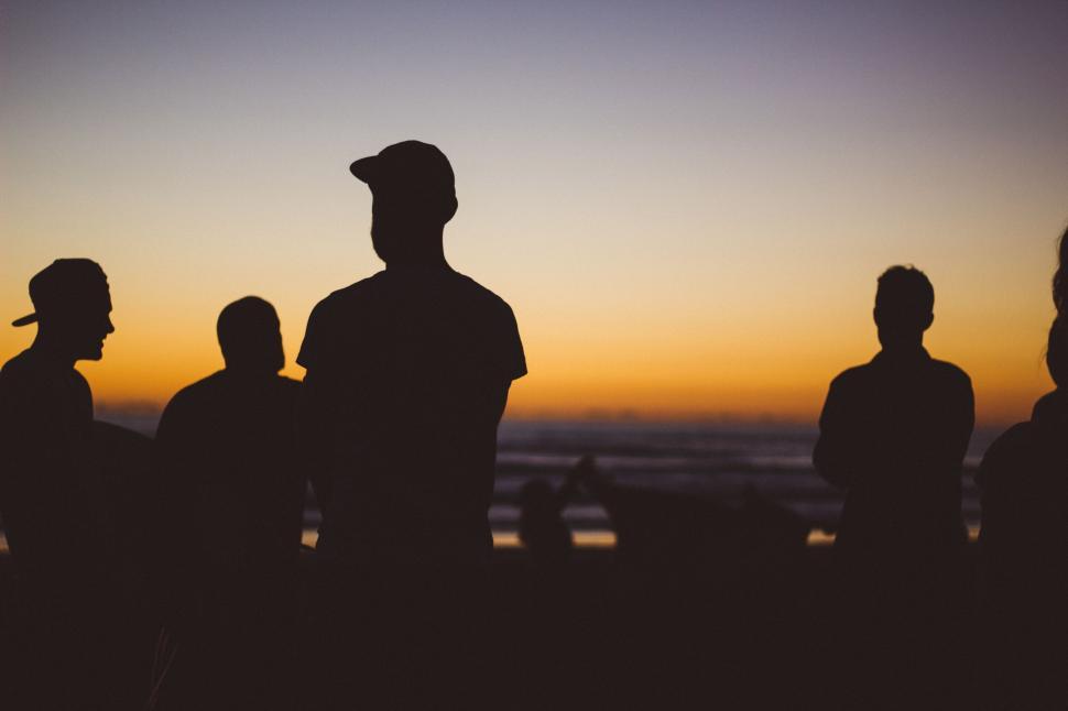 Free Image of Group of people silhouettes at the beach sunset 