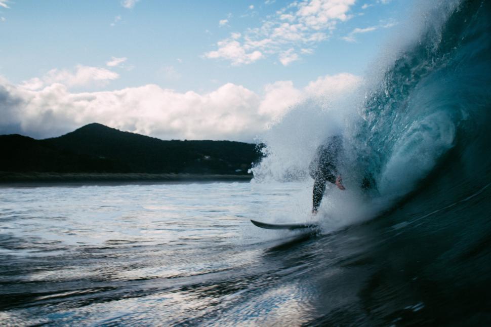 Free Image of Surfer carving through a powerful wave on his surfboard. 