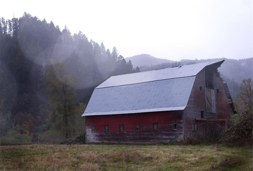 Free Image of Rustic red barn standing in misty mountainside landscape 