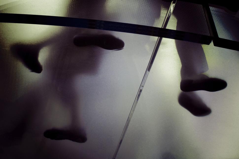 Free Image of People walking on translucent floor with shoes visible 