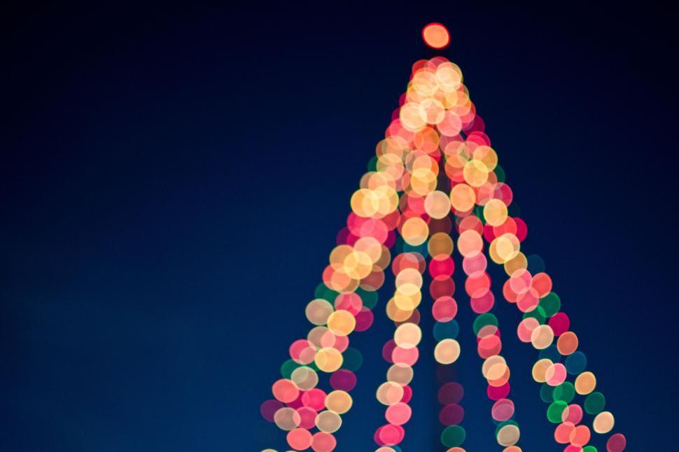 Free Image of Blurred festive Christmas tree lights on dark sky. 