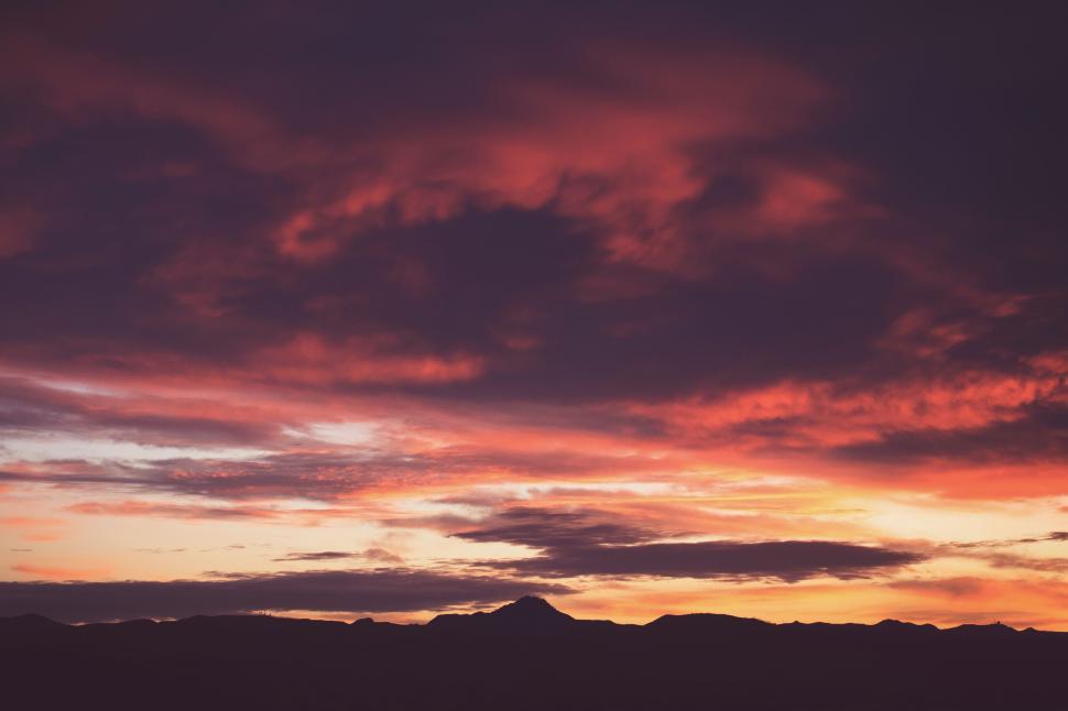 Free Image of Dramatic sunset over mountain silhouette landscape. 