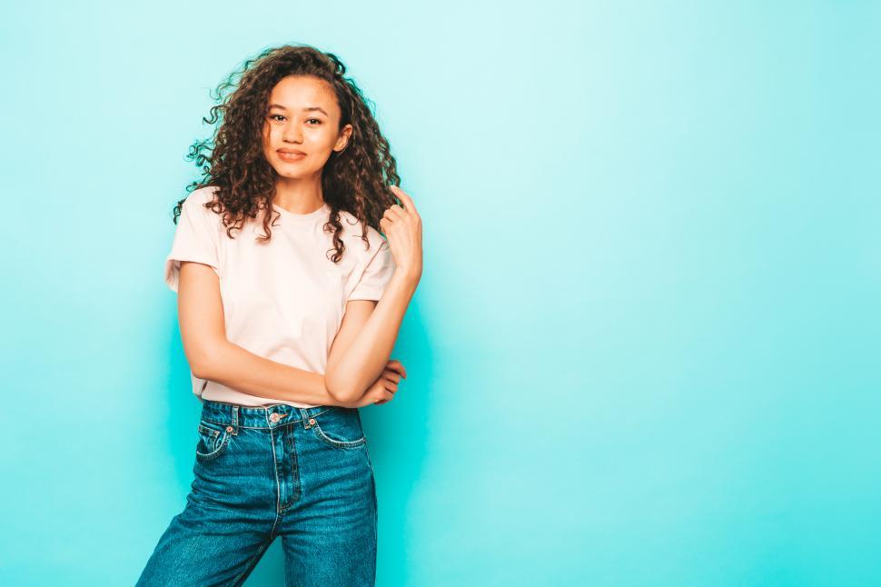 Free Image of Smiling woman in casual pink t-shirt and blue jeans. 