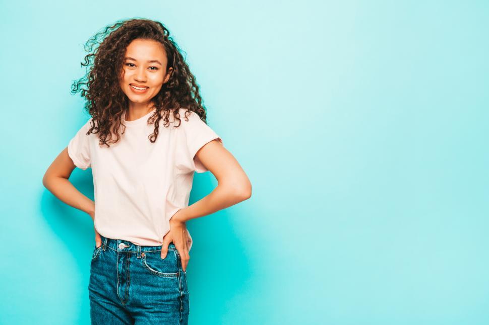 Free Image of Joyful woman in casual attire against blue background. 