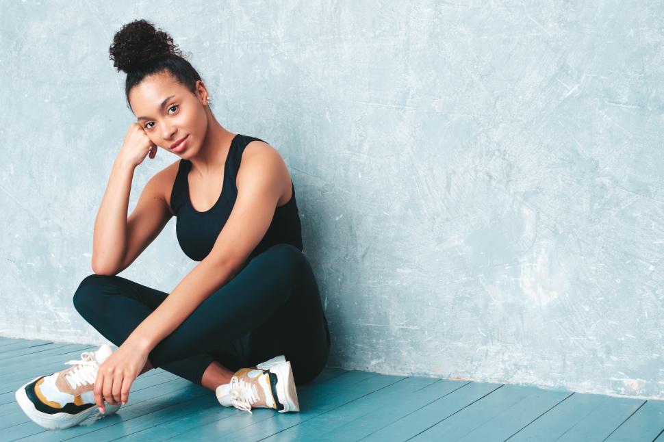 Free Image of Seated woman smiling in black athletic clothing 