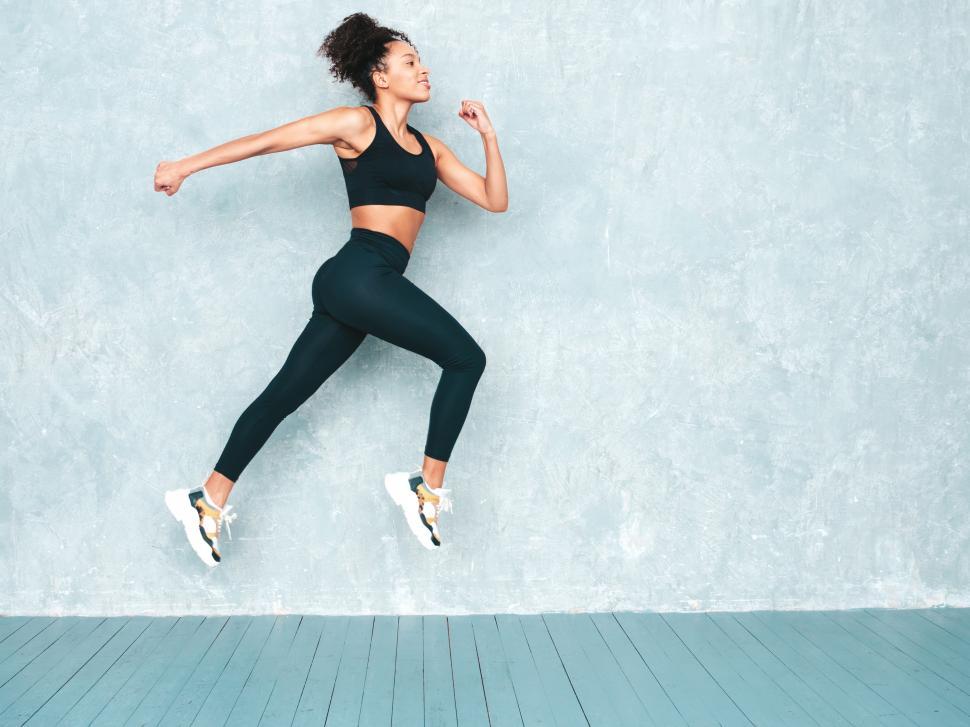 Free Image of Person jumping in black workout gear, mid-air action 