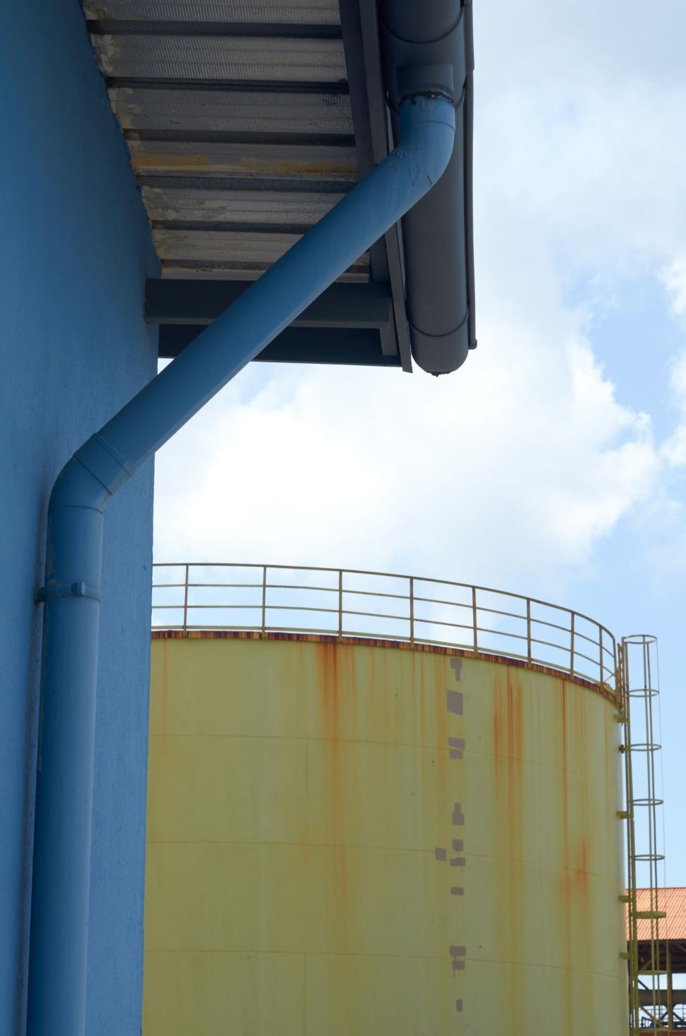 Free Image of Industrial storage tanks with blue gutter and roof 