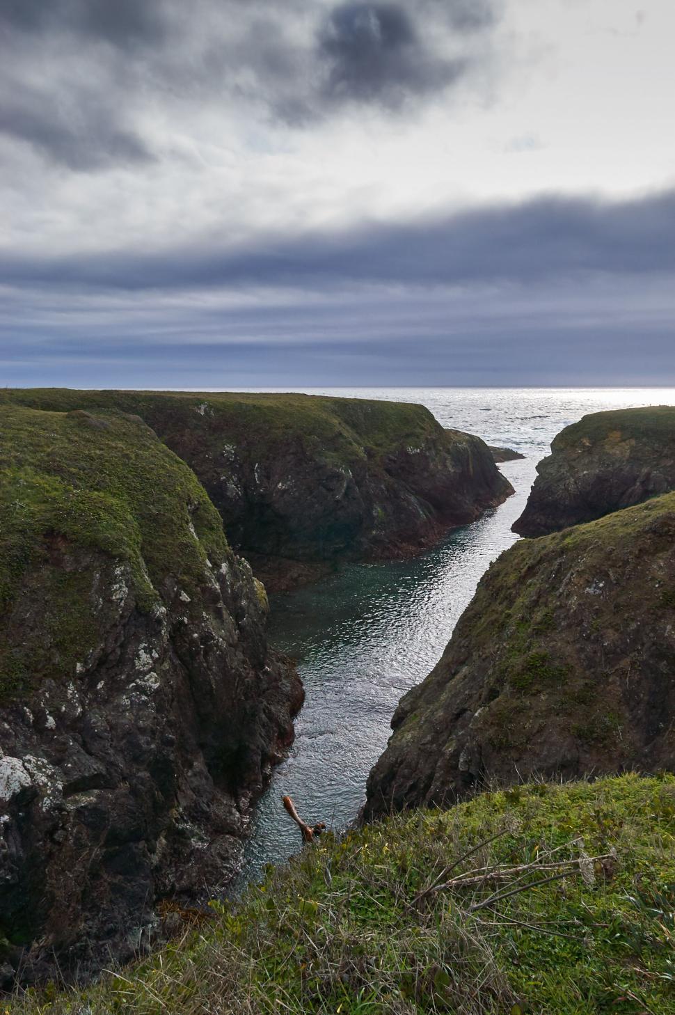 Free Image of Narrow waterway between sheer cliffs under cloudy sky 