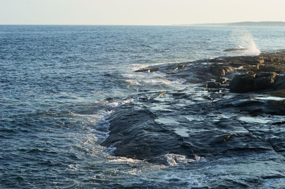 Free Image of Rocky coast with ocean waves crashing onto the shore 