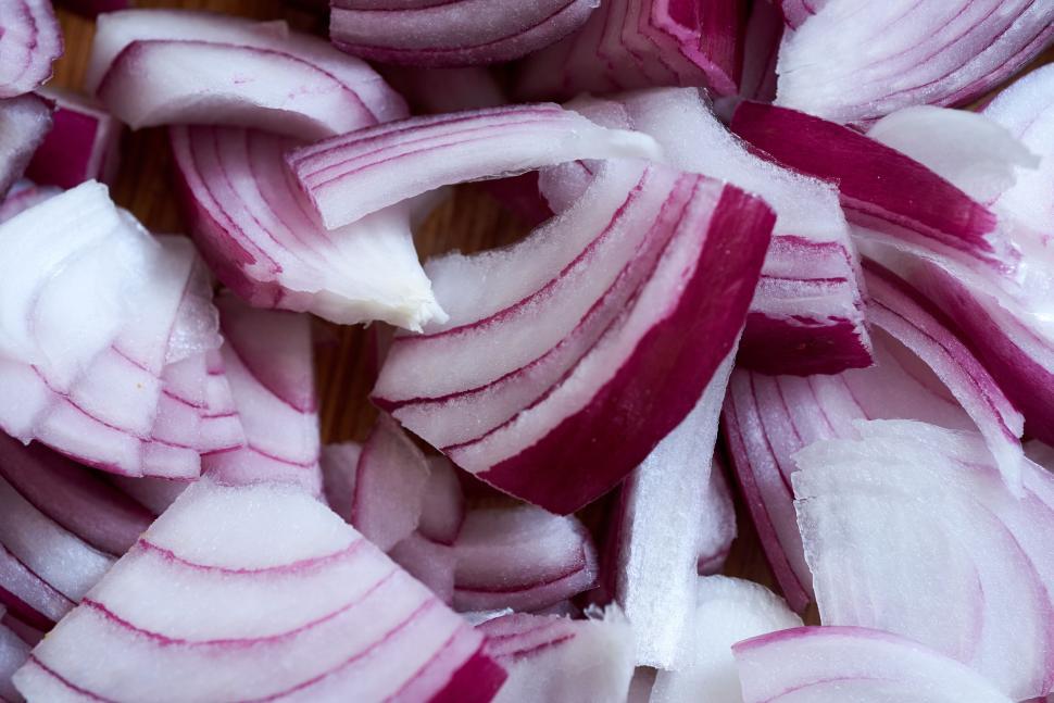 Free Image of Close-up of sliced red onions on a cutting board surface. 