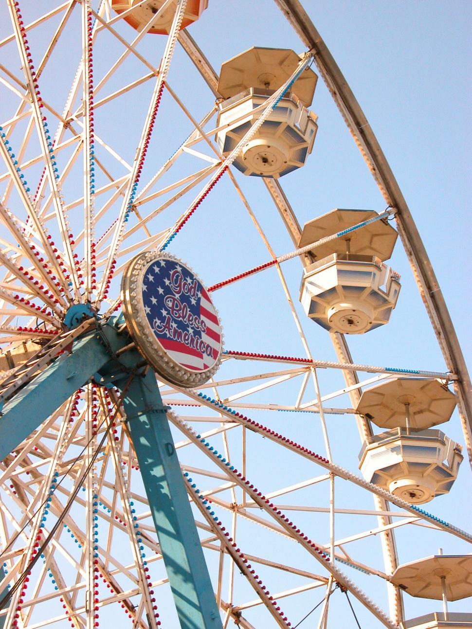 Free Image of Ferris wheel with American flag decoration on a sunny day 