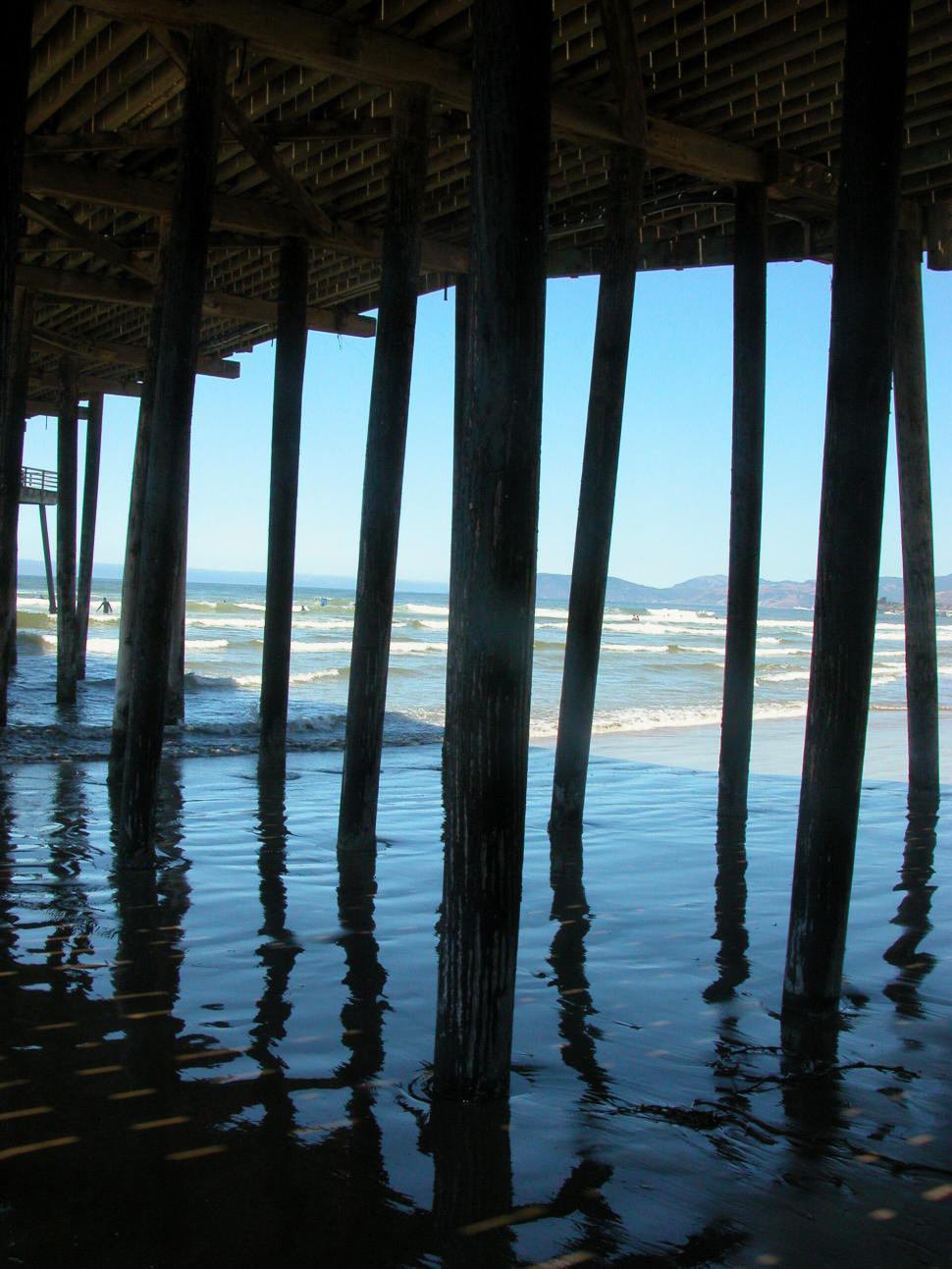 Free Image of View from beneath a pier over the ocean waves 