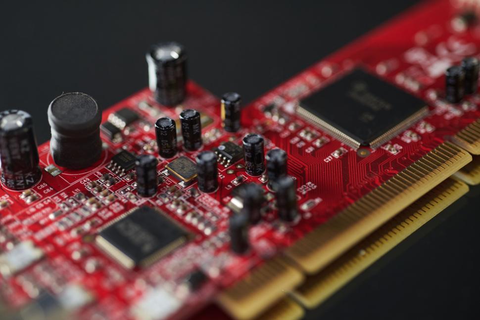 Free Image of Close-up of red circuit board with electronic components. 