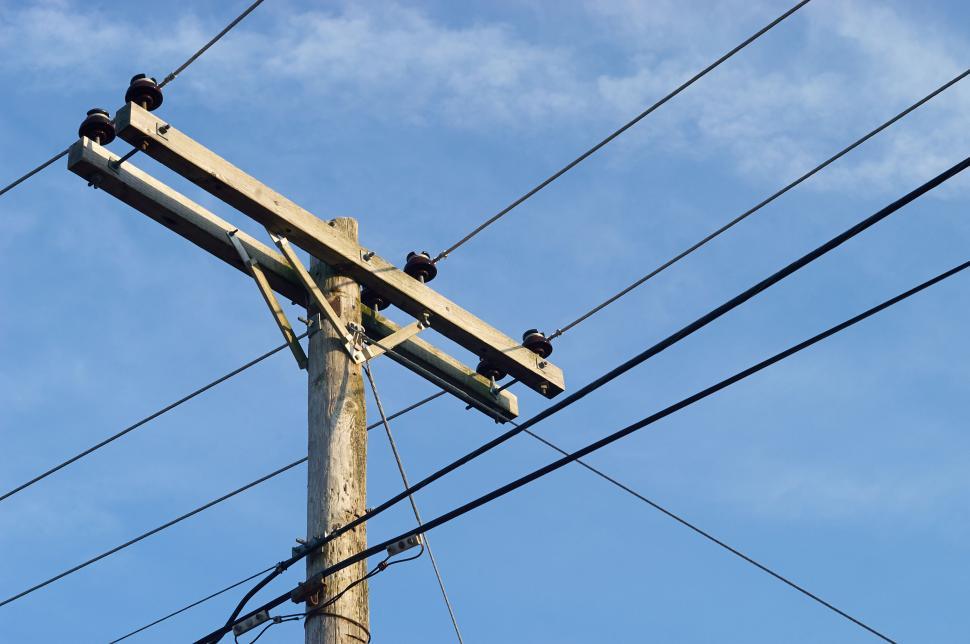Free Image of Wooden telephone pole with cables against clear sky 