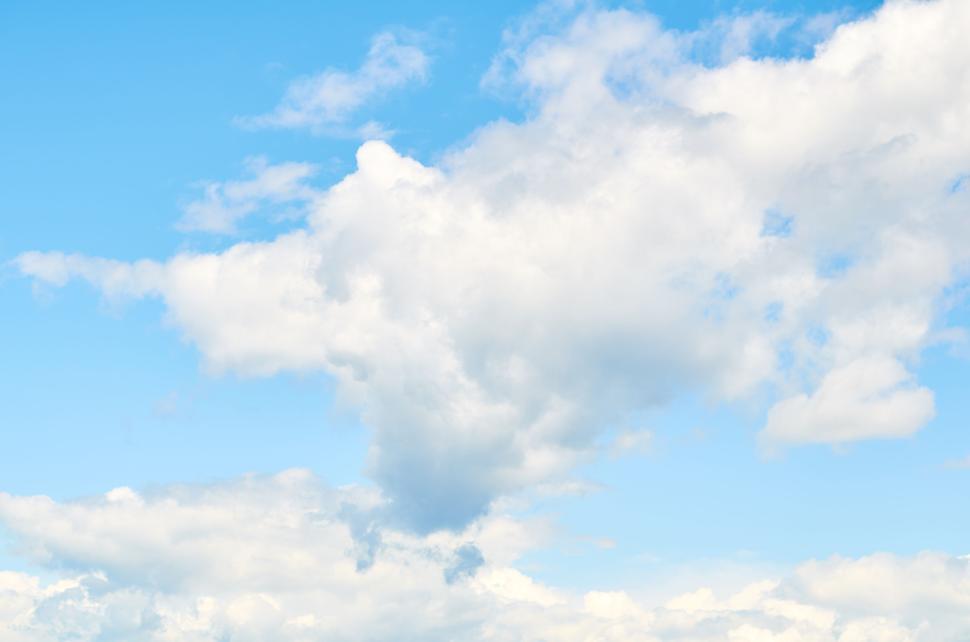 Free Image of Fluffy white clouds against bright blue sky scenery. 
