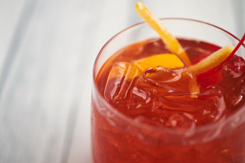Free Image of Chilled red cocktail with ice and citrus garnishes. 