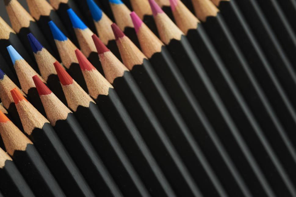 Free Image of Colored pencils arranged in a V-shaped pattern on black 