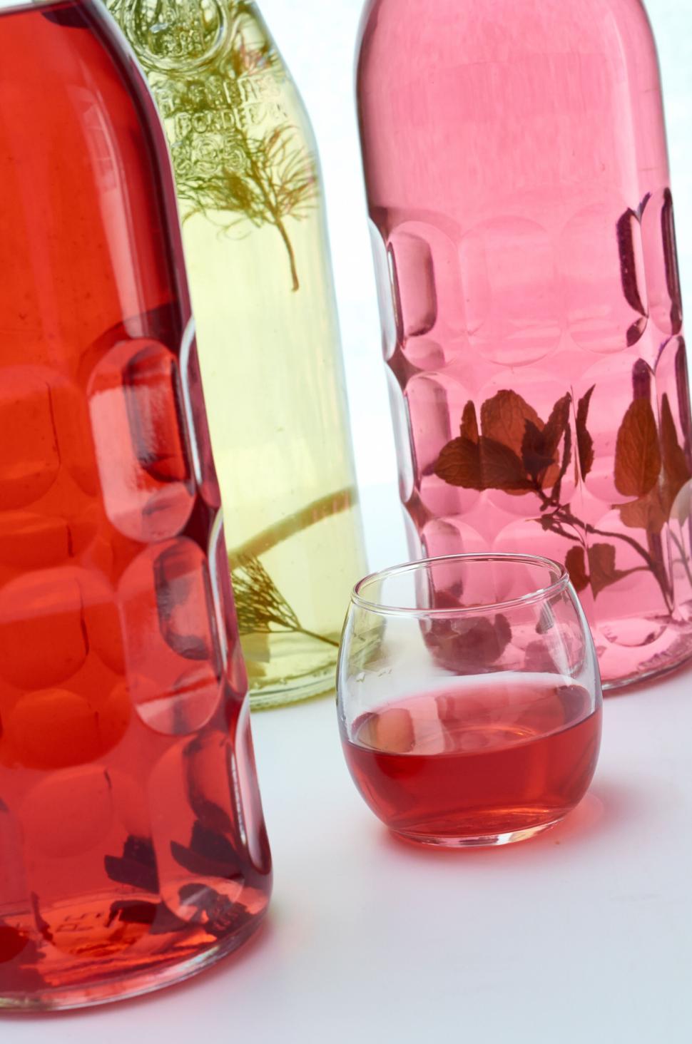 Free Image of Three bottles and glass with colorful drinks 