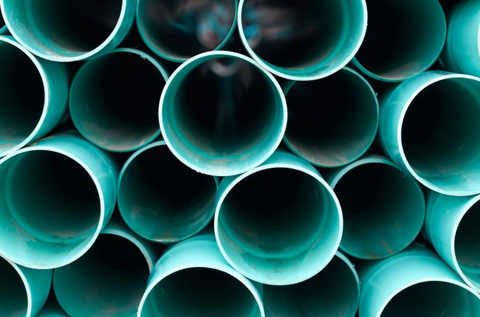 Free Image of Stack of turquoise tubes arranged in a circular pattern 