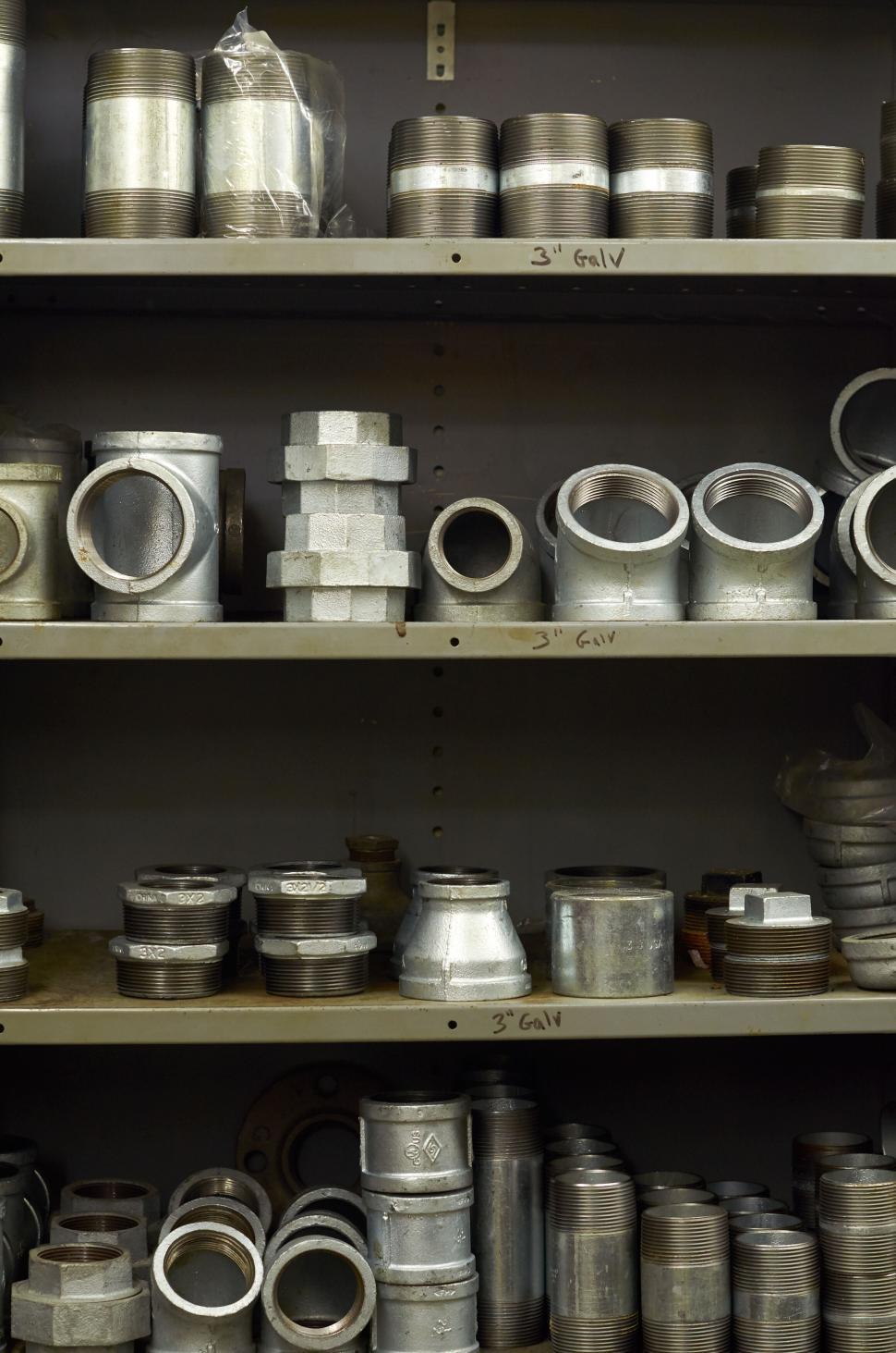 Free Image of Assorted metal pipe fittings on shelves in a workshop 