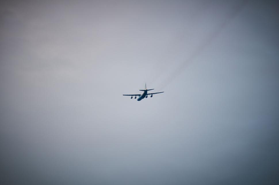 Free Image of Airplane flying away in misty sky during evening hours 