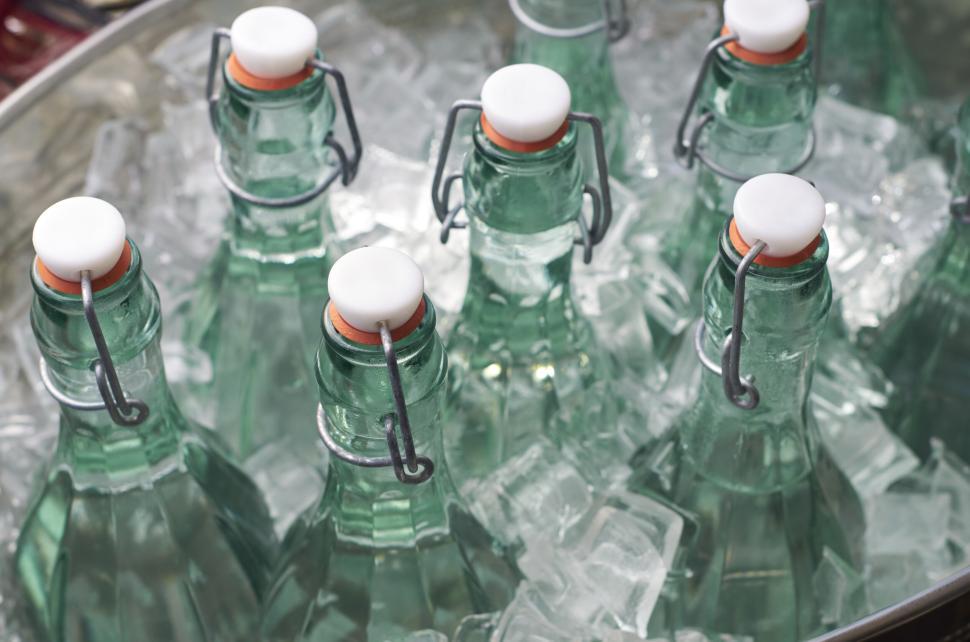 Free Image of Green glass bottles chilling in ice water 