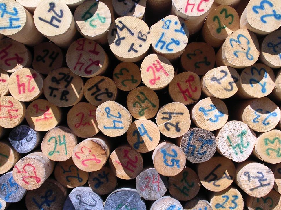 Free Image of Numbered wooden logs stacked together in a pile 