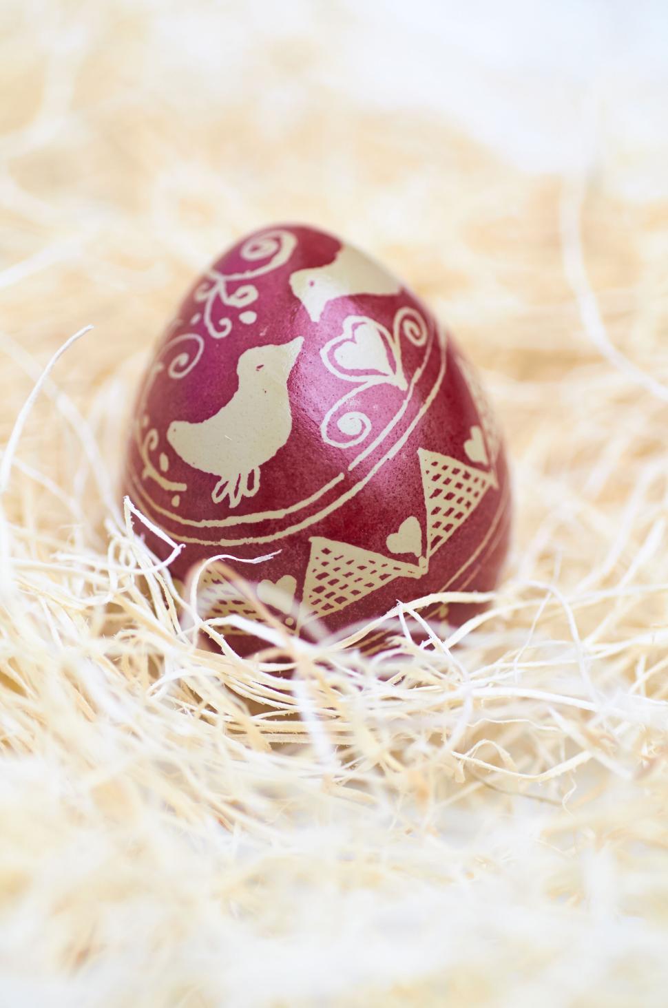 Free Image of Decorated Easter egg resting in a straw-filled nest 