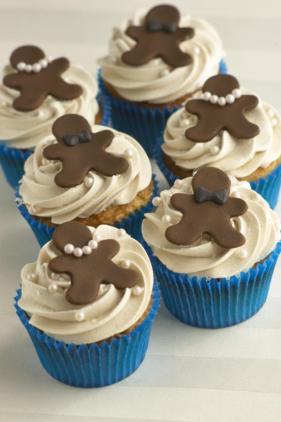 Free Image of Cupcakes with gingerbread men figures on top 