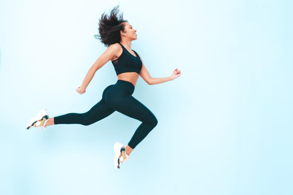 Free Image of Woman mid-jump emphasizing fitness and dynamism 