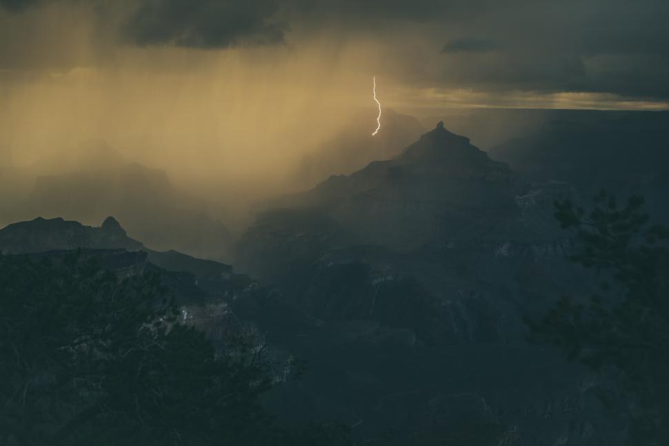 Free Image of Thunderstorm over mountains with visible lightning bolt. 