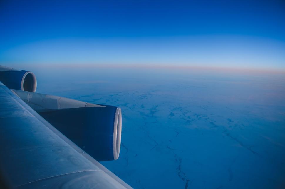Free Image of Airplane wing view over high-altitude snowy landscape 